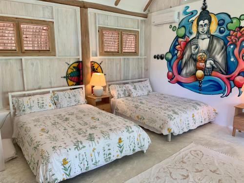 a bedroom with two beds and a painting on the wall at Ki-Ra in Boca de Chavón