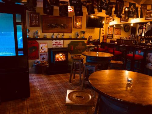 a bar with tables and a fireplace in a room at Goose & Gander Downings in Downings
