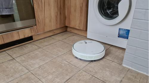 a washer and dryer sitting on the floor in a laundry room at Spokojny Wypoczynek 4 in Ostrów Wielkopolski