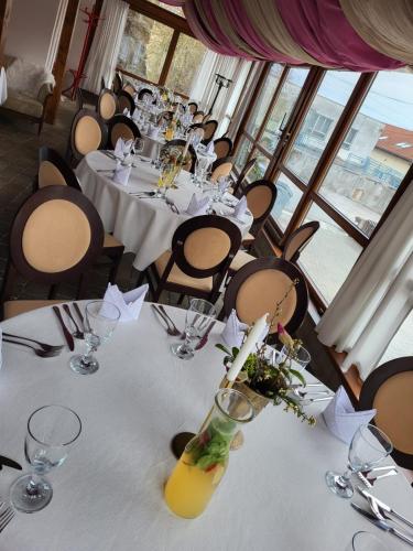 a dining room with white tables and chairs at Kaštieľ Ottlýk in Bánovce nad Bebravou