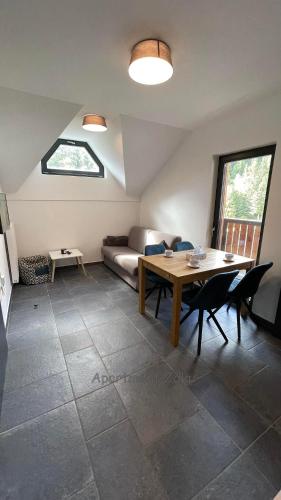 a living room with a table and a couch at Apartma Zala, Golte in Mozirska Koča