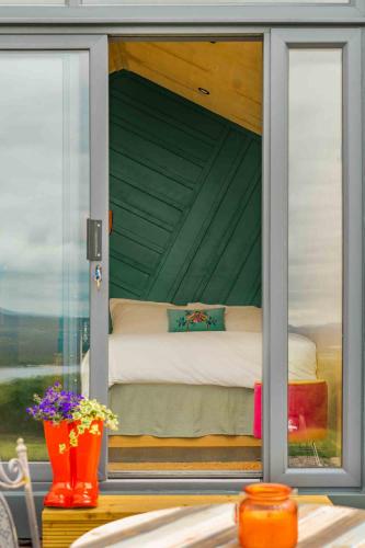 a room with a bed inside of a window at Oaklane Glamping Cabins in Kenmare