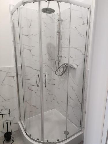 a shower with a glass door in a bathroom at Hostel 36 in Katowice