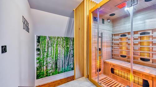 La salle de bains est pourvue d'une douche à l'italienne et d'une fresque murale représentant les arbres. dans l'établissement Apartament Cicha 11 VIP z SAUNĄ by Royal Aparts, à Świeradów-Zdrój