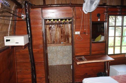a room with a door in a room with wooden walls at Eden Lanta Bungalow in Ko Lanta