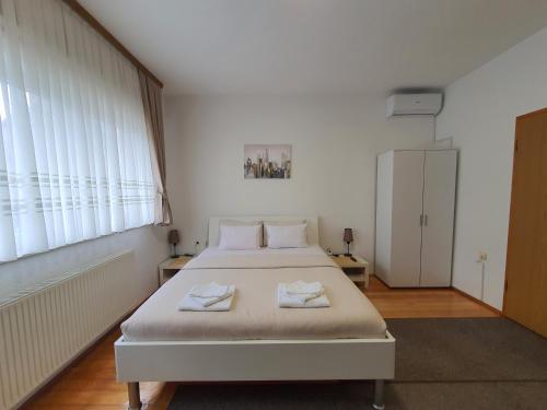a bedroom with a bed with two towels on it at Studio Apartman 11 in Bihać