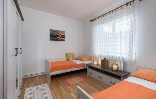 a bedroom with two beds and a window at 2 Bedroom Gorgeous Apartment In Kostrena in Kostrena
