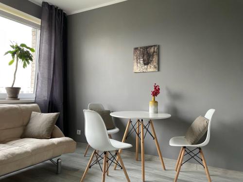 salon ze stołem, krzesłami i kanapą w obiekcie Милая квартира в 7 км от Таллинна w mieście Maardu