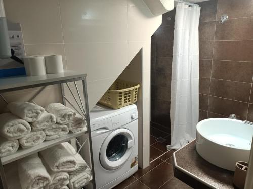 uma casa de banho com uma máquina de lavar roupa e um lavatório em Kalian Meteora em Kalabaka