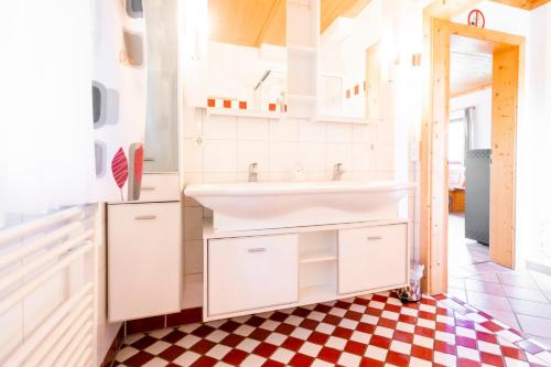 a bathroom with a sink and a checkered floor at Ahornhütte in Schladming