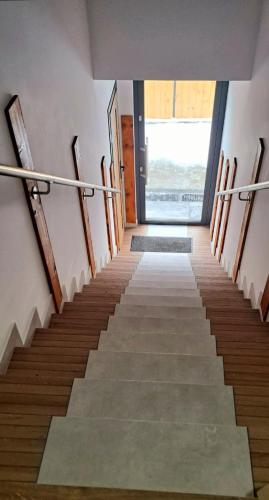 a staircase in a building with wooden stairs and a door at Mini Apartament Rynek in Zakliczyn