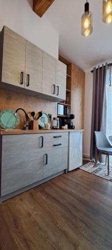 a kitchen with a counter with a microwave and a chair at Mini Apartament Rynek in Zakliczyn