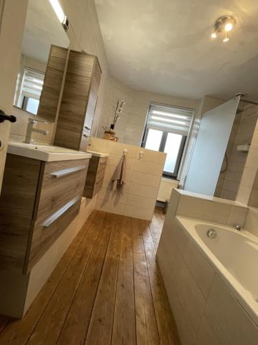 a bathroom with a tub and a sink and a toilet at Vakantiewoning Bij de Jep in Bilzen