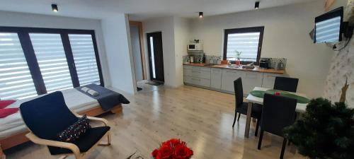 a bedroom with a bed and a table with chairs at Apartamenty U Piotra in Czarny Dunajec