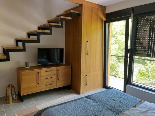 ein Schlafzimmer mit einem Bett, einem TV und einer Treppe in der Unterkunft Domus in natura 