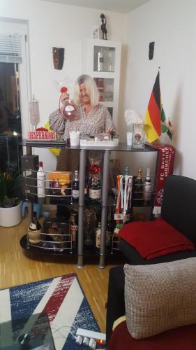 a woman sitting at a table in a room at 1 apartment with 2rooms in München in Munich