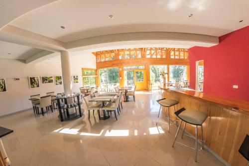 un restaurant avec des tables, des chaises et des murs rouges dans l'établissement Ruca Kuyen Golf & Resort, à Villa La Angostura