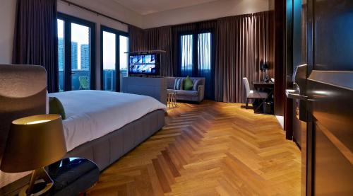 a bedroom with a bed and a desk and a television at Hotel Indigo Tel Aviv - Diamond District by IHG in Tel Aviv