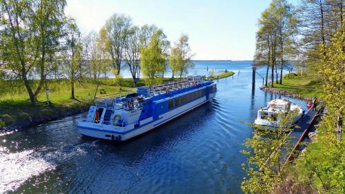 a blue and white boat on a river at Bei den Heidebirken in Nossentiner Hütte in Nossentiner Hütte