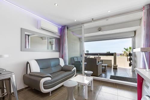 un salon avec un canapé et une table dans l'établissement Emplacement N°1 Port Nature 4, coursive vue mer, 2ème étage, village naturiste, au Cap d'Agde