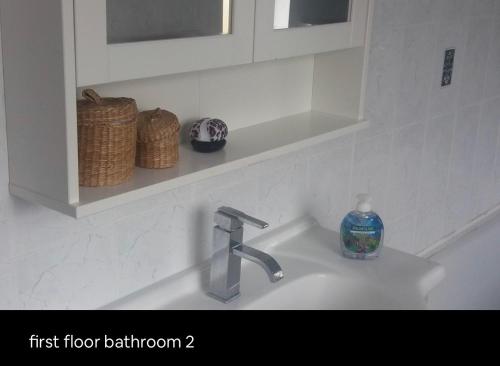 a bathroom sink with a soap bottle on it at Double Rooms in Shared Home in Enfield
