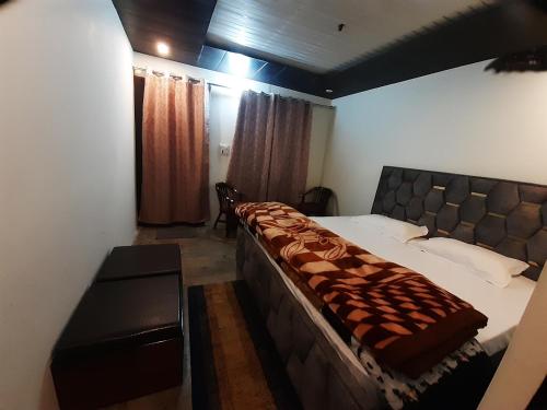 a bedroom with a large bed and a desk at Lake Haven Resort, Sari, Chopta in Sari
