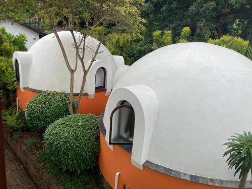 a circular house with an orange and white facade at Dome Home Accommodation in Nelspruit