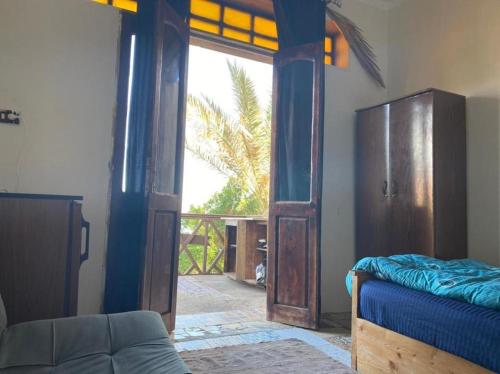 a bedroom with a bed and a door to a balcony at SHANTY HOUSE in Dahab
