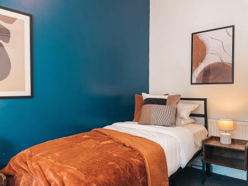 a bedroom with blue walls and a bed at Hamilton House by Solace Stays in Merthyr Tydfil