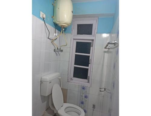 a bathroom with a toilet and a window at Cherry Village Resort, Pelling, Sikkim in Pelling
