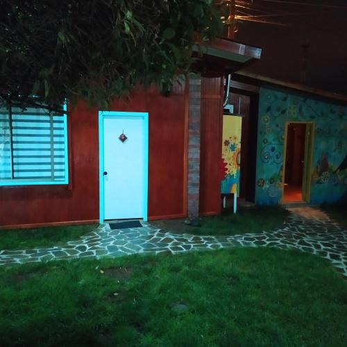 a blue door on the side of a house at night at alojamiento Lof tüng in Los Vilos