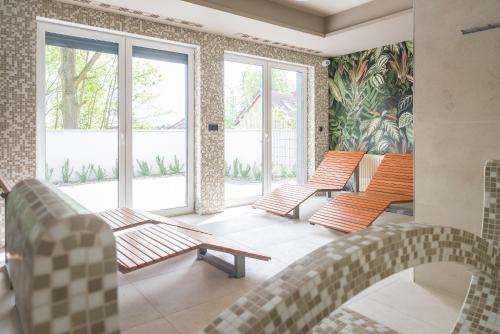 a room with chairs and tables and windows at Apartament z kominkiem.. and SPA, MyWeek in Polanica-Zdrój