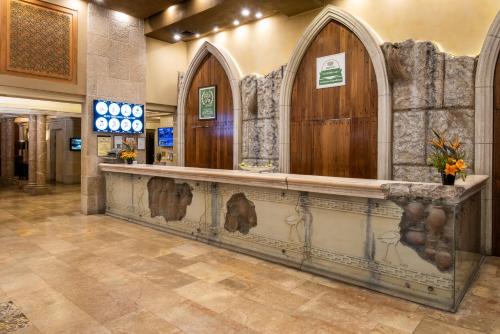 a hotel lobby with a reception counter with arched doors at Olive Tree Hotel in Jerusalem