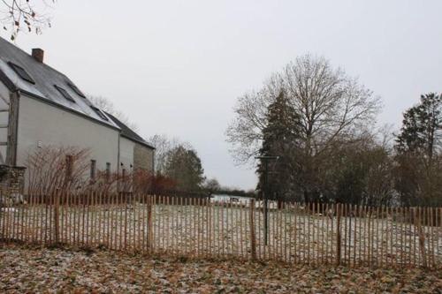 a fence in front of a house with a yard at Au chant du coq in Wancennes