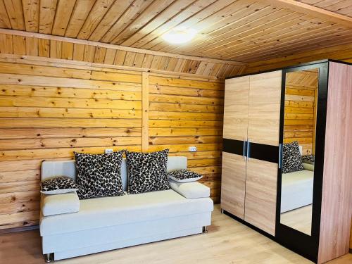 Habitación con sofá en una pared de madera. en Belvedere-Karpaty-Panorama en Skhidnitsa