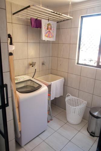 a small bathroom with a sink and a tub at Ap Cozy Calhau prox PRAIA in São Luís