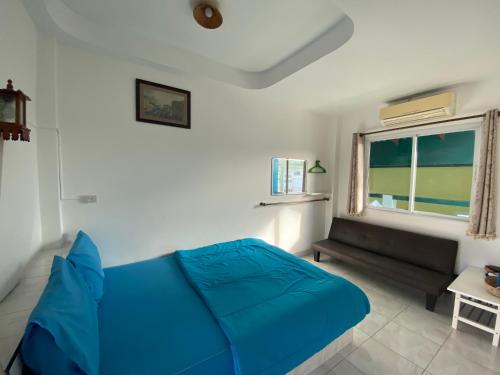 uma cama azul num quarto com uma janela em Winnerview Zone B em Ko Larn