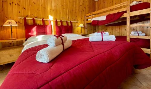 a bedroom with two bunk beds and a red bed at Case Vacanza Perron in Sauze dʼOulx