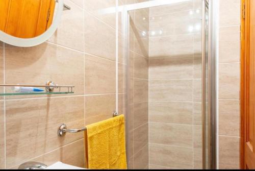a bathroom with a shower with a yellow towel at Georges57 2-Bed Apartment in Inverness in Inverness
