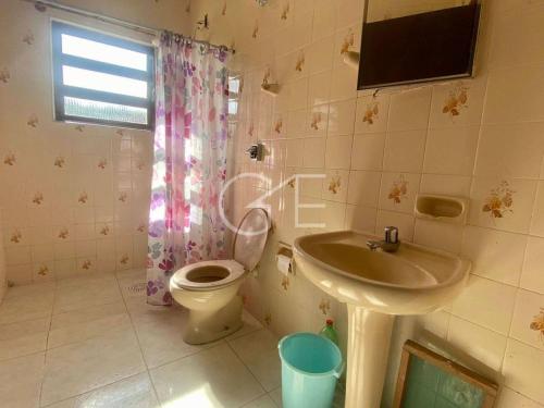 een badkamer met een toilet en een wastafel bij Chacara em Itanhaem - Jardim São Fernando in Itanhaém