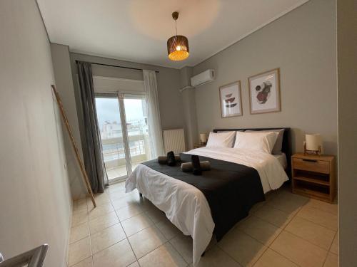 1 dormitorio con cama y ventana grande en Filoxenia - Ολόκληρο διαμέρισμα, en Volos