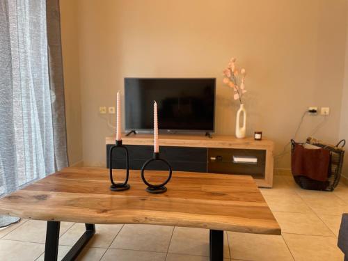 una mesa con dos velas delante de un televisor en Filoxenia - Ολόκληρο διαμέρισμα, en Volos