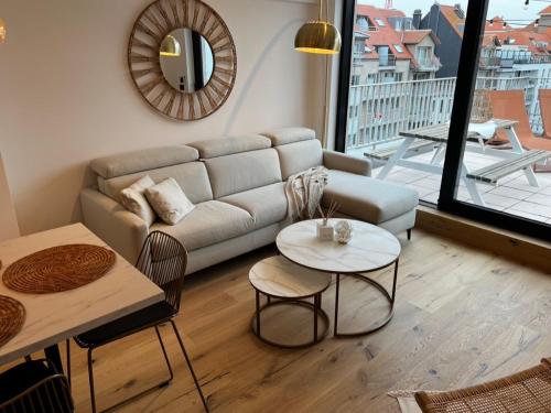 ein Wohnzimmer mit einem Sofa und einem Tisch in der Unterkunft Sea5 @ Nieuwpoort! Penthouse bij zee en winkels in Nieuwpoort
