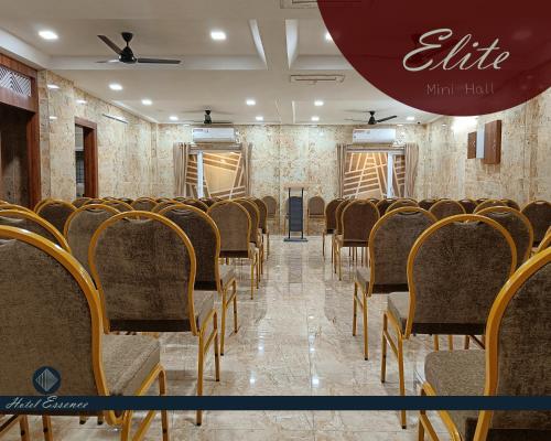 a room with rows of chairs and a red umbrella at Hotel ESSENCE in Vellore