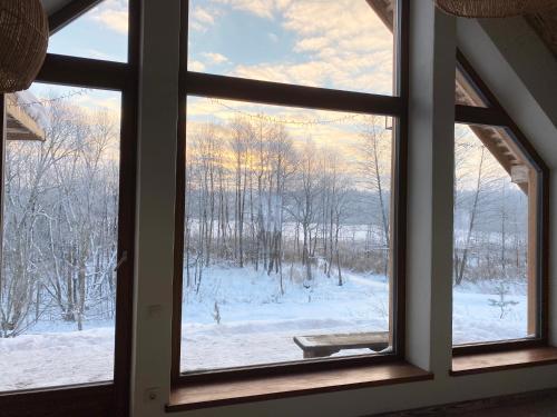 a window with a view of a snow covered field at Dabintos slėnis in Sumiliszki