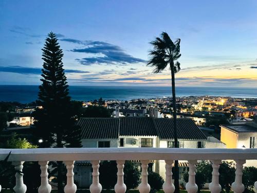 a view of a city from a balcony with a palm tree at Casa Yaya Nerja in Nerja