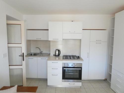 a kitchen with white cabinets and a stove at La dimora degli Angeli in Moggio