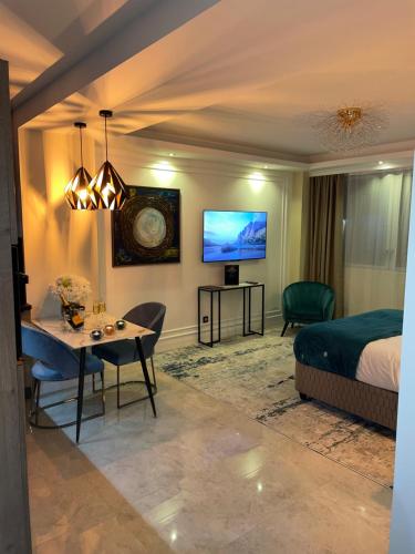 1 dormitorio con cama, mesa y TV en NUITS D'HERMES & Spa en Chalon-sur-Saône