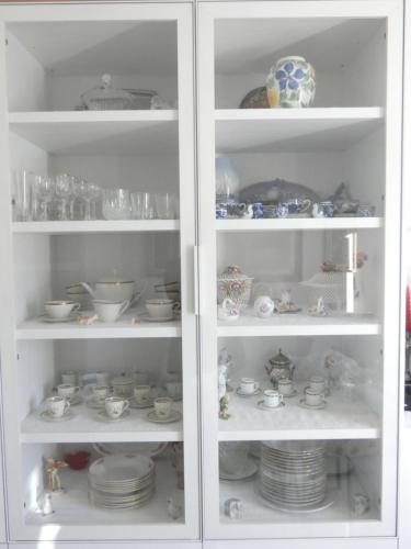 a white cabinet filled with dishes and cups and plates at La dimora degli Angeli in Moggio