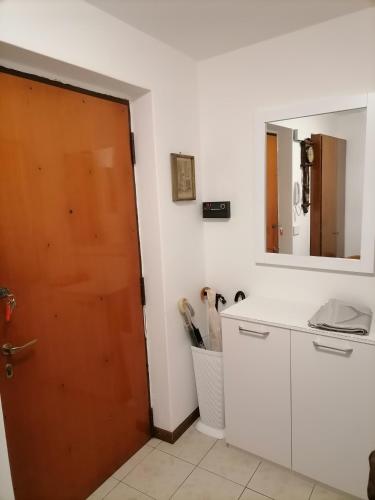 a bathroom with a door and a mirror at La dimora degli Angeli in Moggio